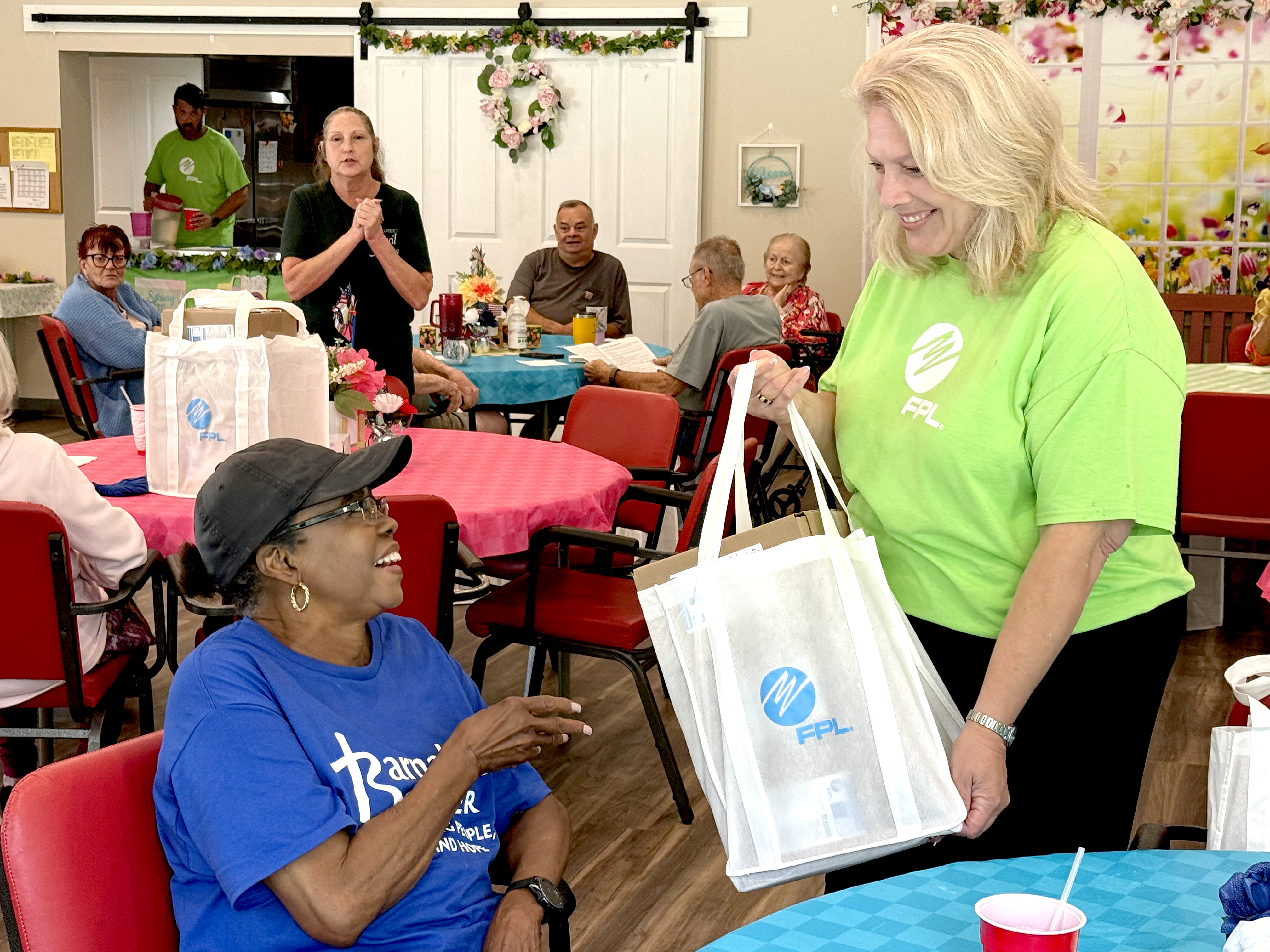Hilliard resident Bernita Dinwiddie receives a meal kit from Carol Saviak, FPL external communications manager. The meal kits include shelf-stable items to assist senior citizens in the event of a power failure due to a storm. 
