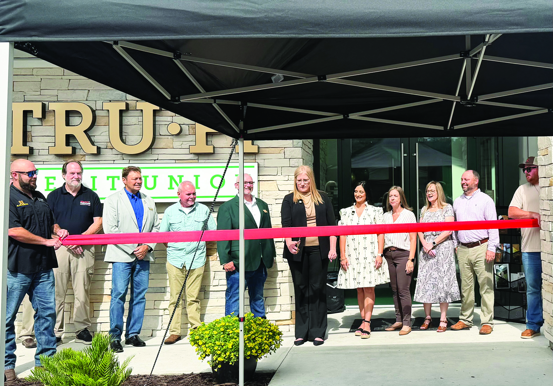 TRU-FI Credit Union officials and community members participate in a ribbon-cutting ceremony celebrating the grand opening of the credit union’s newly built Callahan branch Tuesday. The former branch was torn down after construction completed. Photo by Britney Fletcher West