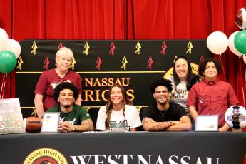 West Nassau High School senior Danyelle Bell is joined by mom Sarah Monds, grandmother Ellen Monds, and brothers Chaz Davis, Prentiss Davis, and Brisyn Holmes as she signs with Mercyhurst University March 9. 