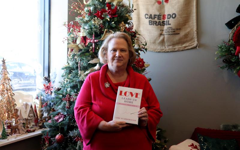Lori Scarborough poses above with her book “Love Leads Us Home,” available on westbowpress.com and Amazon. Photo by Anna Newhoff