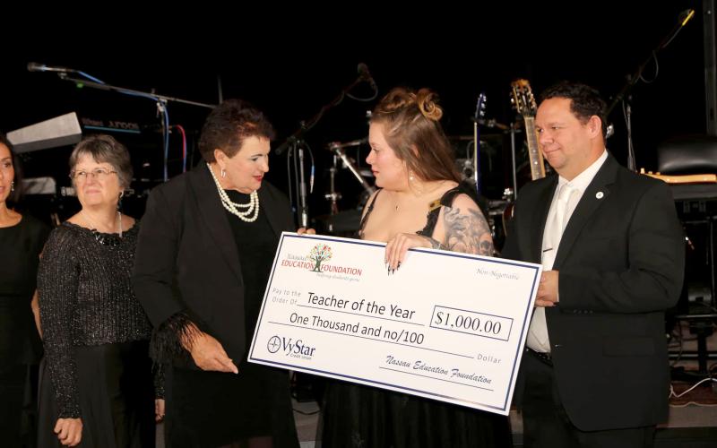 Callahan Intermediate School fourth grade teacher Kayla Hooper is the Nassau County Teacher of the Year. She accepts a ceremonial $1,000 check from Nassau County Schools Superintendent Kathy Burns as Nassau County School Board member Joe Zimmerman stands nearby at the Nassau Education Foundation Teacher of the Year Black and White Gala.