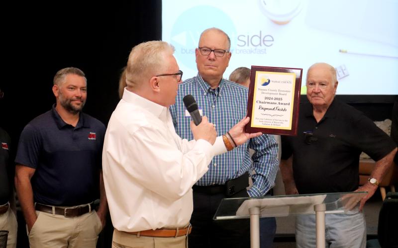 Paul Schwend announces that Raymond Fachko, center, is the recipient of the 2024-25 Nassau County Economic Development Board Chairman’s Award. They are joined by Jacob Hagan, left, and Fred Pike, as well as several friends and family members. Photo by Amanda Bishop