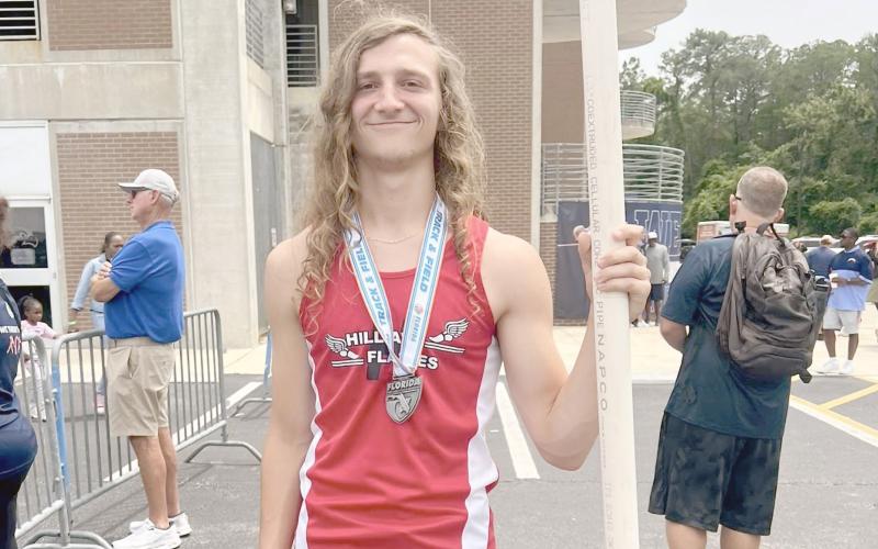 Justin Bennett poses with a javelin while wearing his state medal. He competed in the Class 1A boys javelin, placing eighth out of 18 state qualifiers after a rain delay.