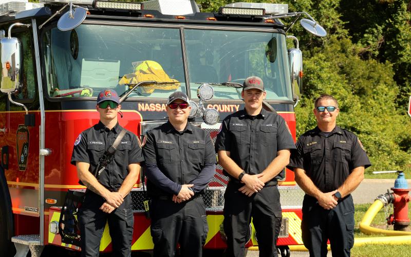 Nassau County Fire Rescue first responders Thomas Peacock, Lt. Jeremy Roberts, Ryan Deeley, and Capt. Brian Sloan stand together in front of the new aerial ladder truck.
