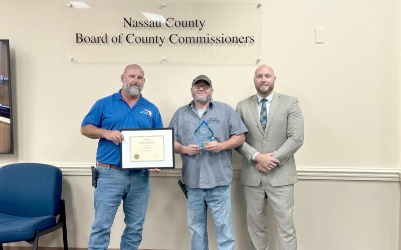 Journeyman facilities technician Josh Powell, center, recently completed his 20th year with the Nassau County Board of Commissioners. With Powell is Facilities Manager Tony Lombardi, left, and County Manager Taco Pope.