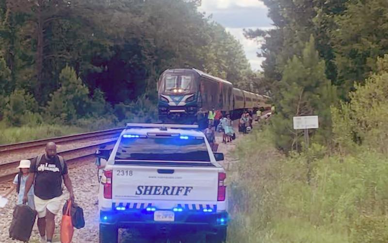 Amtrak passengers carry their  belongings toward Jackson-ville Transportation Authority  buses in Boulogne Sunday aft- ernoon. Train 41 lost power, coming to a stop just inside Nassau County. It was headed to Miami from Chicago at the time. Nassau County Fire Rescue, the Nassau County Sheriff’s Office and other local agencies and departments assisted the Amtrak passengers.  Photo courtesy of the Nassau County Sheriff’s Office