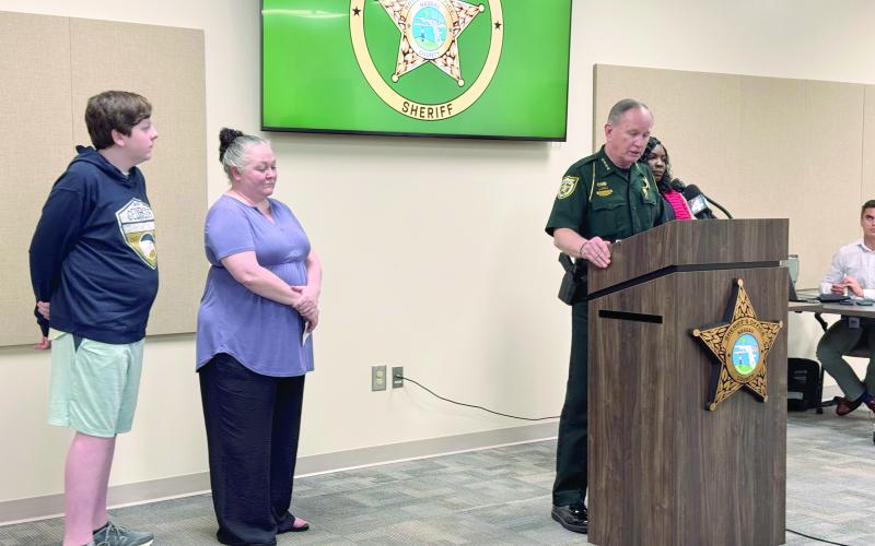 Nassau County Sheriff Bill Leeper speaks at the press conference Aug. 20 with victim Aaron Wiese and his mother, Amy Wiese, and Victim Advocate Madrina Addison nearby. Leeper warned parents to be vigilant about monitoring their children’s internet and social media activity. Photo by Anna Newhoff