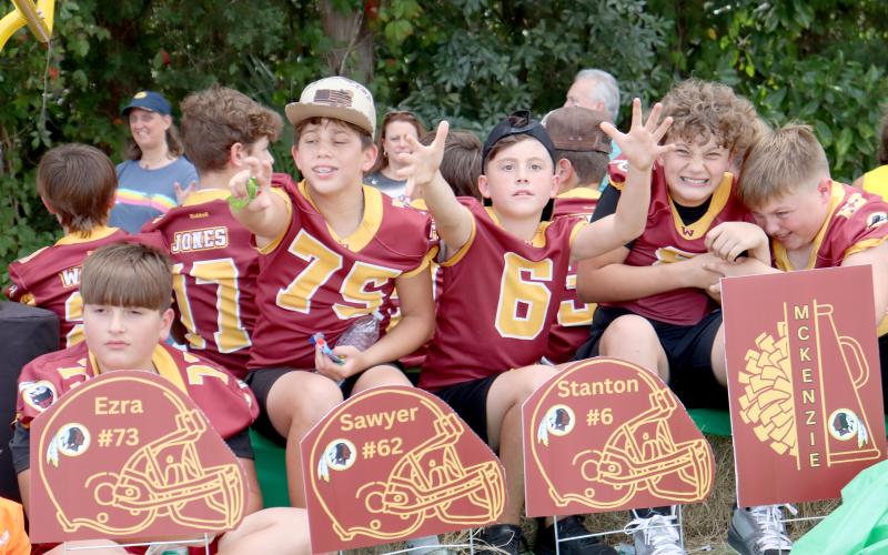 Little Warriors reach for candy being thrown at their float during Friday’s West Nassau High School homecoming parade.
