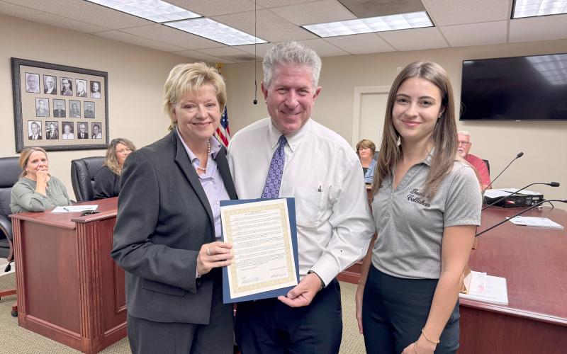 Emily’s Promise Presid-ent Doug Adkins and Vice  President Janet Adkins join Callahan Town Coun-cilwoman Jacquelyn Fle-ming Monday. The council declared October as Emily Adkins Blood Clot Awareness Month. Photo by Anna Newhoff