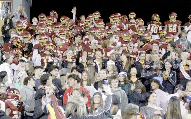 The Warrior football team joins The Tribe student section in the stands after the game to celebrate their victory over Fernandina Beach Friday.