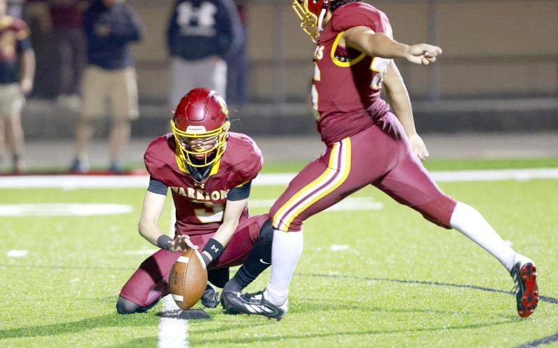 Pryce Arnold holds the ball for kicker Gavin Velazquez, who added an extra point to the Warriors’ side of the scoreboard. Photos by Brian LaCross, www.fb.com/LaCrossImages