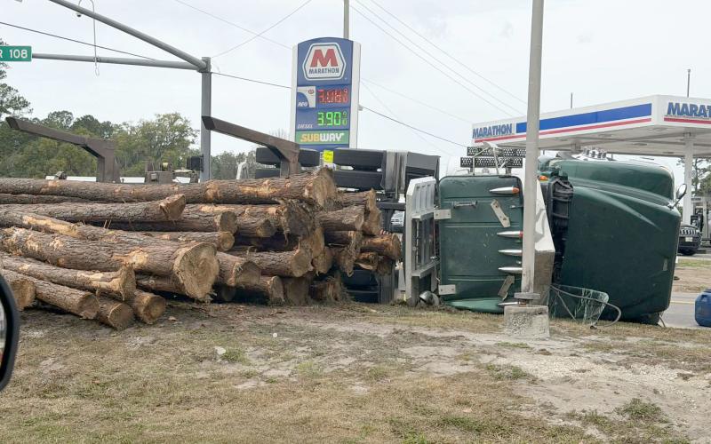 Logs spill onto the ground near the Circle K gas station across from the Marathon at the intersection of County Road 108 and U.S. 1 in Hilliard Monday morning. The driver was not injured. Photo by Amanda McCullough