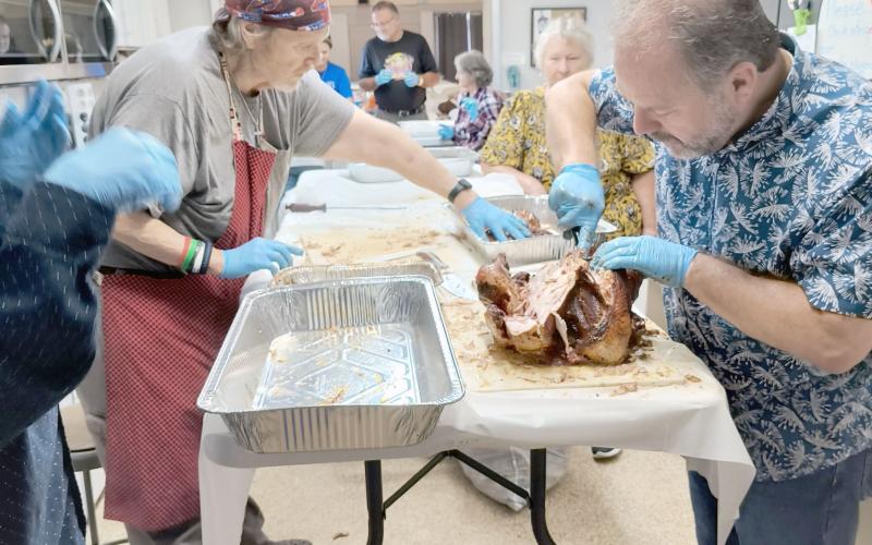 Callahan Methodist Church Pastor Bodie Riddle and David Haskett carve turkey as the church congregation prepares to serve Thanksgiving dinner to community members Nov. 22. The tradition began 45 years ago. This year’s menu included smoked turkeys, a variety of side dishes, and desserts. Attendees enjoyed the meal and fellowship with other patrons. Photos by Susie Bass