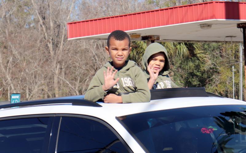 Kids wave from a sunroof.