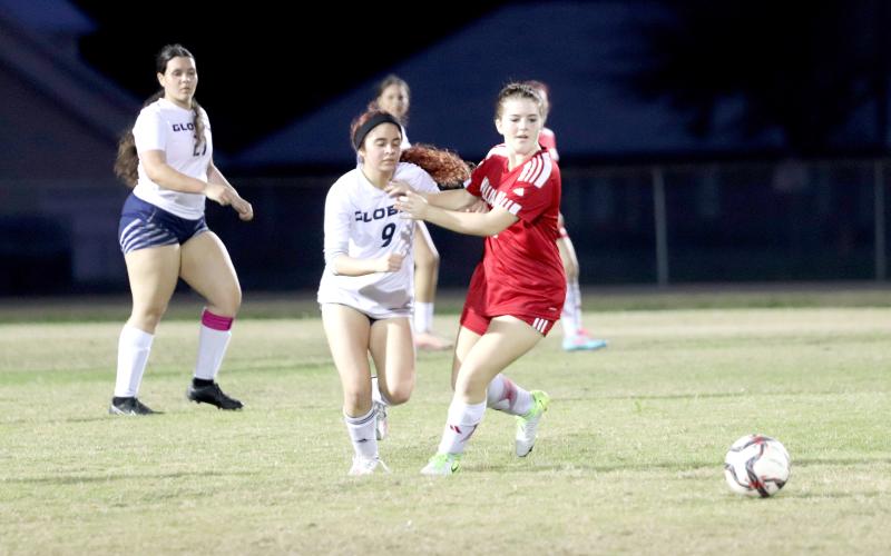 Hannah Wollitz battles a Lady Kodiak as they race for the ball.