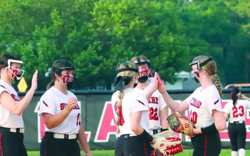 illiard’s Avery Vennard, Zoe Gray, and Neveah Brown high five before the start of an inning at top left as the Lady Flashes face off with the Lady Warriors Friday night.