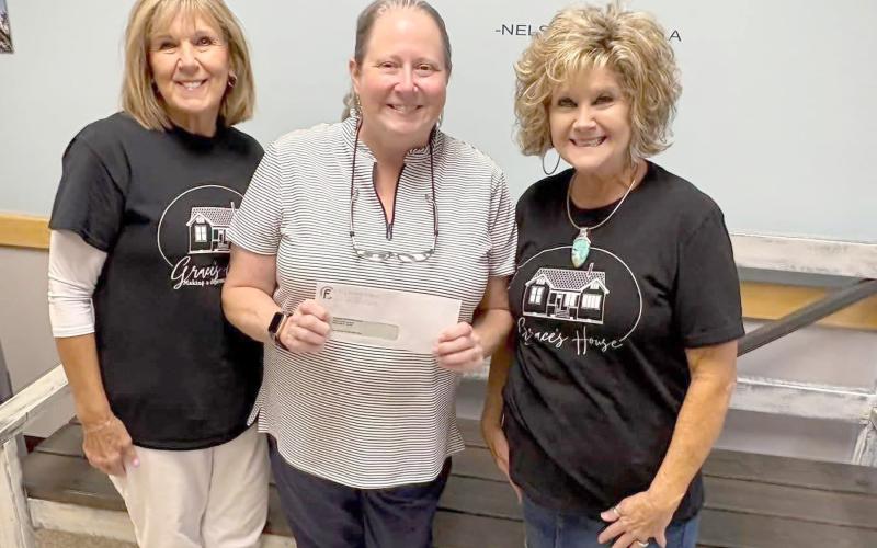 Bryceville Elementary School Principal Tammy Smith receives a $4,580 donation from Grace’s House volunteers Sharon Manning and Peggy Hyatt.