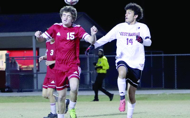 Hilliard soccer player Clayton Floyd hits a header with Warrior David Ortega nearby in December.