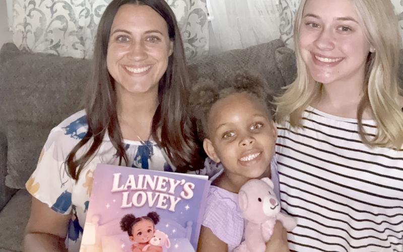Mahryah, Lainey, and Emma White pose with “Lainey’s Lovey” and the lovey that comforts Lainey, now 6. She was the inspiration for the book about children in foster care. Submitted
