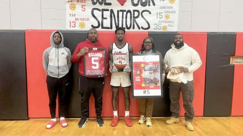 CJ Hall displays his 1,500-point basketball as he is honored Jan. 20. He is joined by his family, from left, Carlton Hall, Carlous Hall, Tasha Hall, and Leonard Smith. The Hilliard Middle-Senior High School athlete is in his final year of playing for the Flashes. 