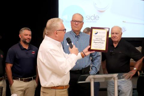 Paul Schwend announces that Raymond Fachko, center, is the recipient of the 2024-25 Nassau County Economic Development Board Chairman’s Award. They are joined by Jacob Hagan, left, and Fred Pike, as well as several friends and family members. Photo by Amanda Bishop