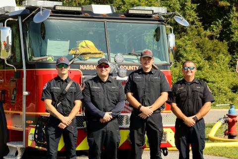 Nassau County Fire Rescue first responders Thomas Peacock, Lt. Jeremy Roberts, Ryan Deeley, and Capt. Brian Sloan stand together in front of the new aerial ladder truck. 
