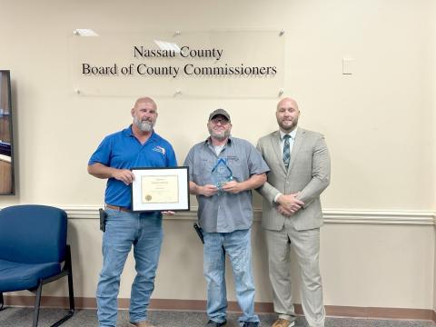 Journeyman facilities technician Josh Powell, center, recently completed his 20th year with the Nassau County Board of Commissioners. With Powell is Facilities Manager Tony Lombardi, left, and County Manager Taco Pope. 