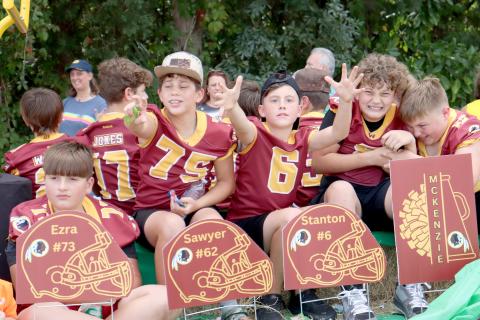 Little Warriors reach for candy being thrown at their float during Friday’s West Nassau High School homecoming parade. 
