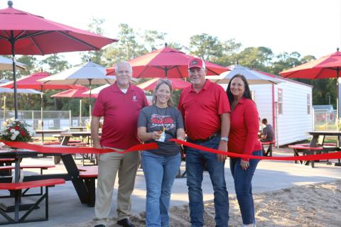 Hilliard Middle-Senior High School art teacher Heather Cash-Canode cuts the ribbon to open the new Alumni Art Courtyard Friday evening. Joining her are Principal John Crawford and Walnut Creek Furniture owners Gene and Treana Jackson. Photos by Anna Newhoff