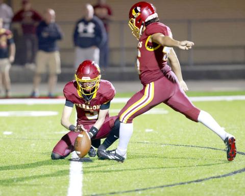 Pryce Arnold holds the ball for kicker Gavin Velazquez, who added an extra point to the Warriors’ side of the scoreboard. Photos by Brian LaCross, www.fb.com/LaCrossImages