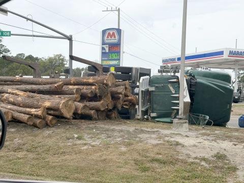 Logs spill onto the ground near the Circle K gas station across from the Marathon at the intersection of County Road 108 and U.S. 1 in Hilliard Monday morning. The driver was not injured. Photo by Amanda McCullough