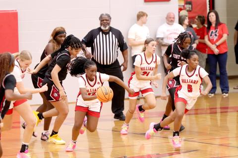 Justice Alderman leads the pack as Hilliard controls the ball. 