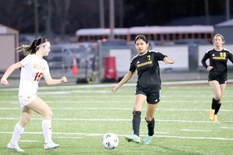 West Nassau’s Brianna Gancerez moves the ball down field as a Lady Wildcat approaches Jan. 13. 