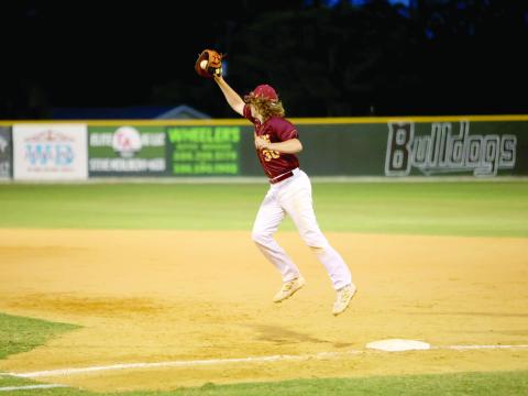 Liam Reeves catches a high throw at first base.