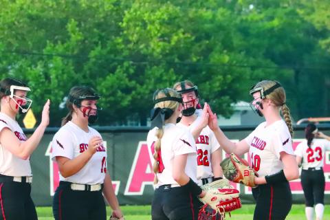 illiard’s Avery Vennard, Zoe Gray, and Neveah Brown high five before the start of an inning at top left as the Lady Flashes face off with the Lady Warriors Friday night. 