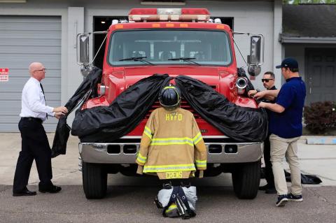 Hilliard Town Councilman Dallis Hunter works with Station 4 volunteer firefighters to adorn the town’s fire apparatus in memory of James “Kevin” Crews, whose funeral was held April 30. Photo by Alicia Head