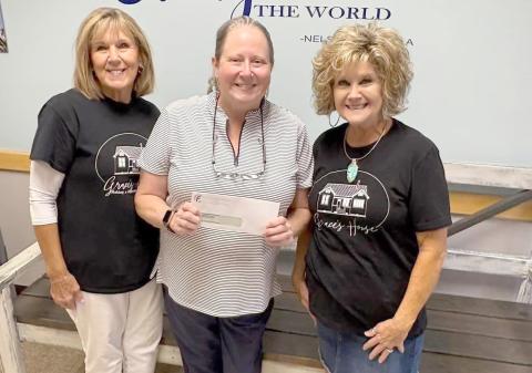 Bryceville Elementary School Principal Tammy Smith receives a $4,580 donation from Grace’s House volunteers Sharon Manning and Peggy Hyatt.