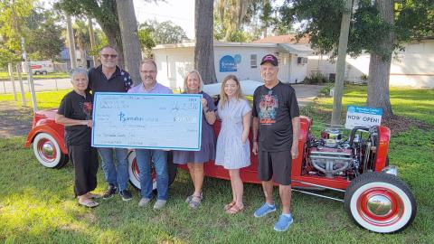 The annual Memorial Day Rod Run 4 Kidz, a mission of Callahan Methodist Church, raised $10,000 for Barnabas Center. Pictured left to right are Cheryl Mangold, Brad Mangold, Pastor Bodie Riddle, Barnabas President and CEO Jamie Reynolds and Community Engagement Manager Trish Thompson, and Jim Mangold. The annual fundraiser is held on the church grounds on the Saturday of Memorial Day weekend, drawing a crowd each year. Photo by Amanda Bishop