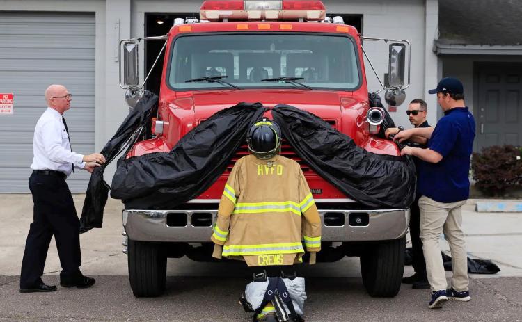 Hilliard Town Councilman Dallis Hunter works with Station 4 volunteer firefighters to adorn the town’s fire apparatus in memory of James “Kevin” Crews, whose funeral was held April 30. Photo by Alicia Head