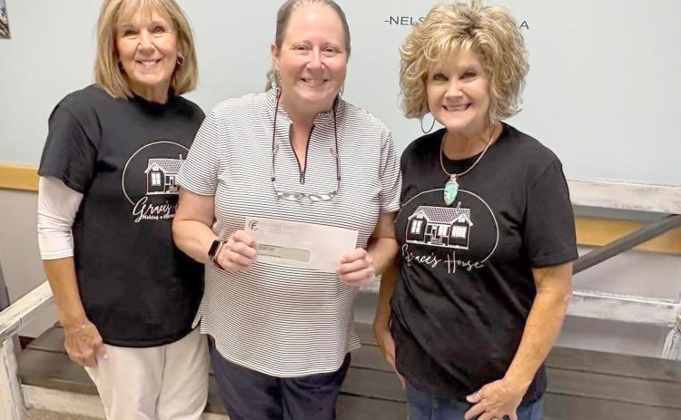 Bryceville Elementary School Principal Tammy Smith receives a $4,580 donation from Grace’s House volunteers Sharon Manning and Peggy Hyatt.