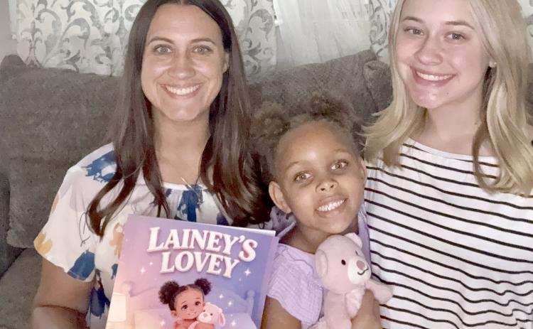 Mahryah, Lainey, and Emma White pose with “Lainey’s Lovey” and the lovey that comforts Lainey, now 6. She was the inspiration for the book about children in foster care. Submitted
