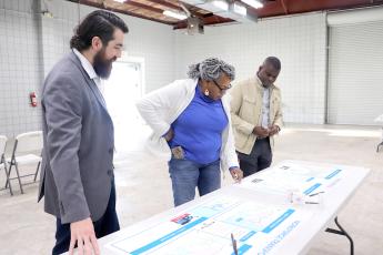 Callahan resident Eleby Harris looks over proposed Jacksonville Transportation Authority plans that could provide bus service to western Nassau residents. She is joined by JTA Director of Planning and Sustainability Xan Traversa and another JTA representative. Photo by Kathie Sciullo