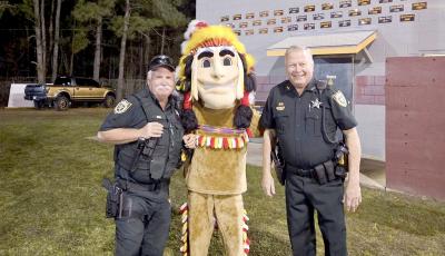 Jimmy Hall and Stephen Johnson, Nassau County Sheriff’s Office reserve deputies, join the Warrior mascot after signing off with NCSO dispatch for their final time Feb. 27.